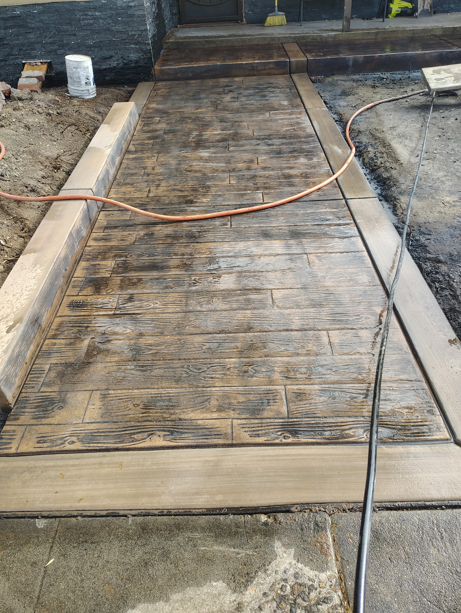 Stamped concrete walkway with wood plank texture and concrete borders
